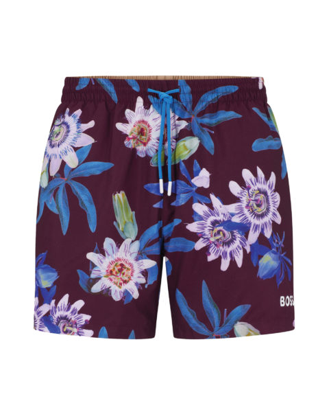 statement swimwear: black swim shorts with dark blue leaves and lighter blue flowers